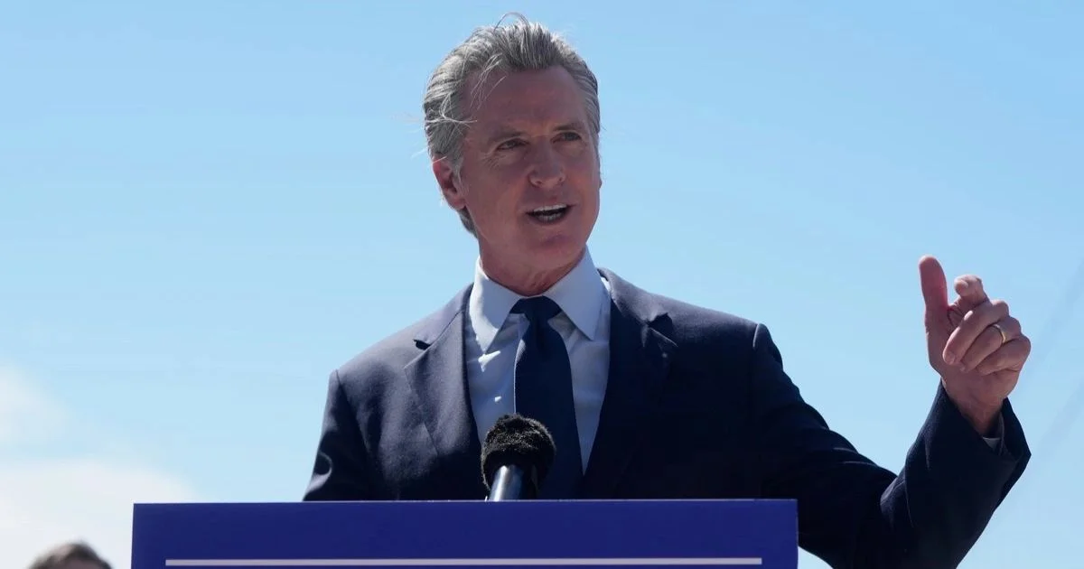 Gavin Newsom durante un acto público sobre seguridad; la nota aborda un interruptor de IA