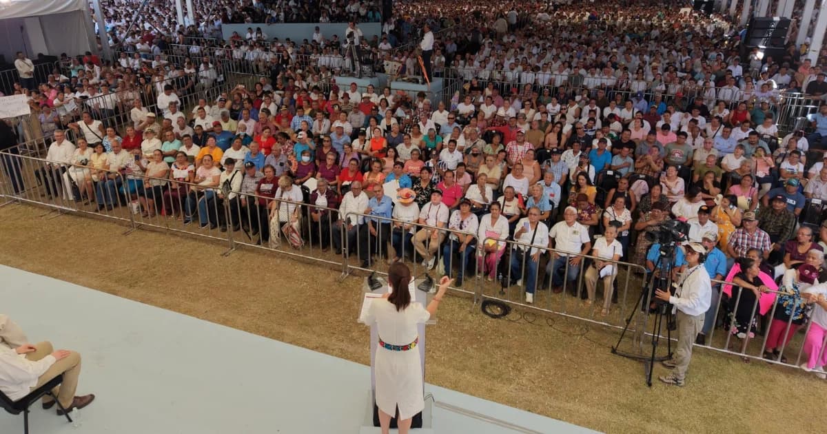 Claudia Sheinbaum habla desde un escenario ante una multitud reunida bajo una estructura techada durante un acto público en Tabasco.