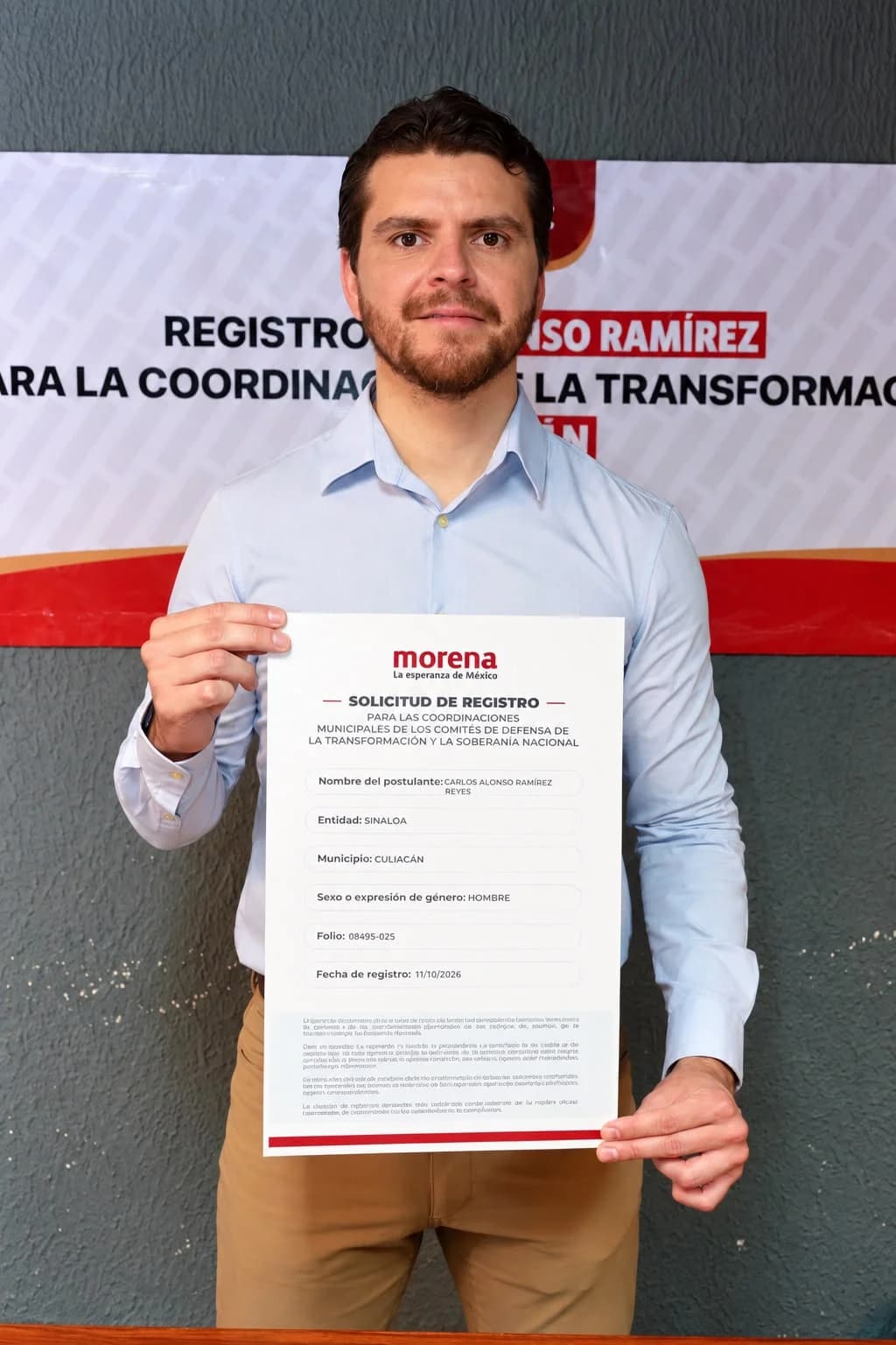 Hombre con camisa azul claro sosteniendo una solicitud de registro de Morena en Culiacán
