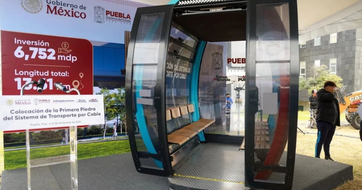 Cabina de muestra del sistema de transporte por cable de Puebla, exhibida junto a un panel de inversión y longitud del proyecto