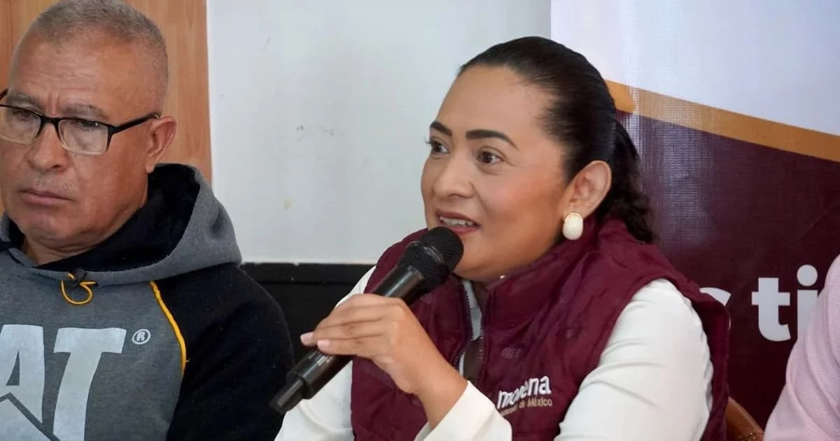 Una mujer con chaleco de Morena interviene con un micrófono en una reunión