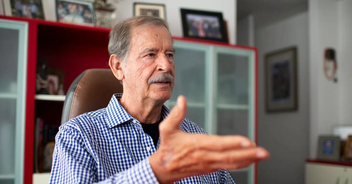 Hombre de camisa a cuadros sentado en una oficina durante una conversación