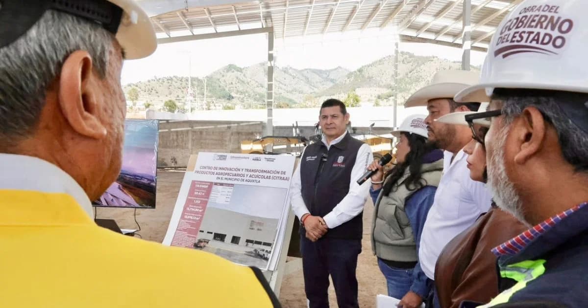 Alejandro Armenta y personal de obra observan la ficha técnica del centro agroindustrial CITRAA en Aquixtla, Puebla