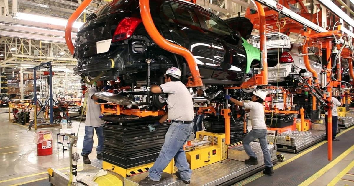 Trabajadores realizan labores de ensamblaje en una línea de producción automotriz