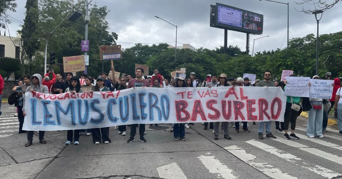 Manifestantes sostienen una manta con las frases «Revocación ya» y «Lemus culero, te vas al basurero» durante una marcha en una avenida de Guadalajara.