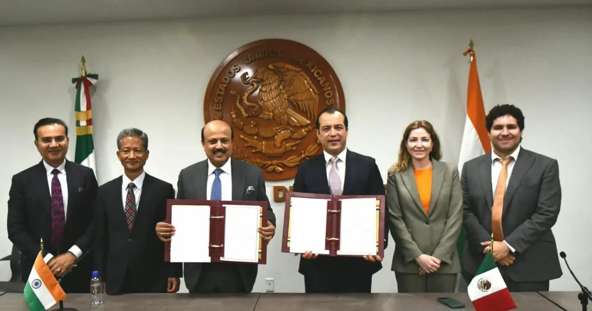 Delegaciones de México e India muestran documentos durante una reunión de cooperación comercial, con banderas de ambos países