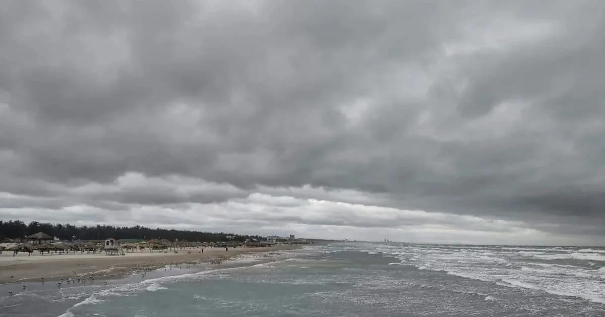 Costa con oleaje elevado bajo un cielo cubierto por nubes oscuras