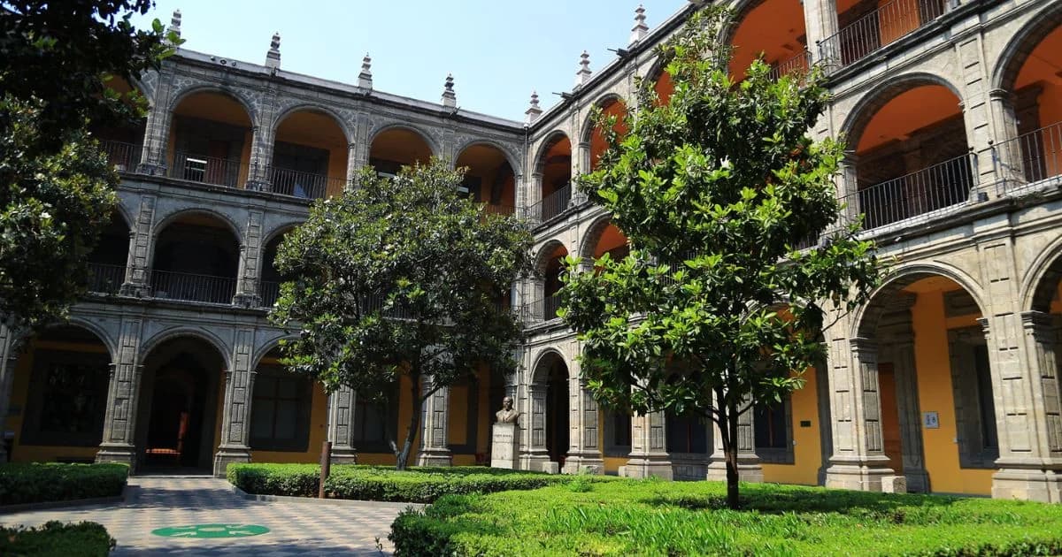 Patio histórico con arquerías de piedra, árboles y jardines