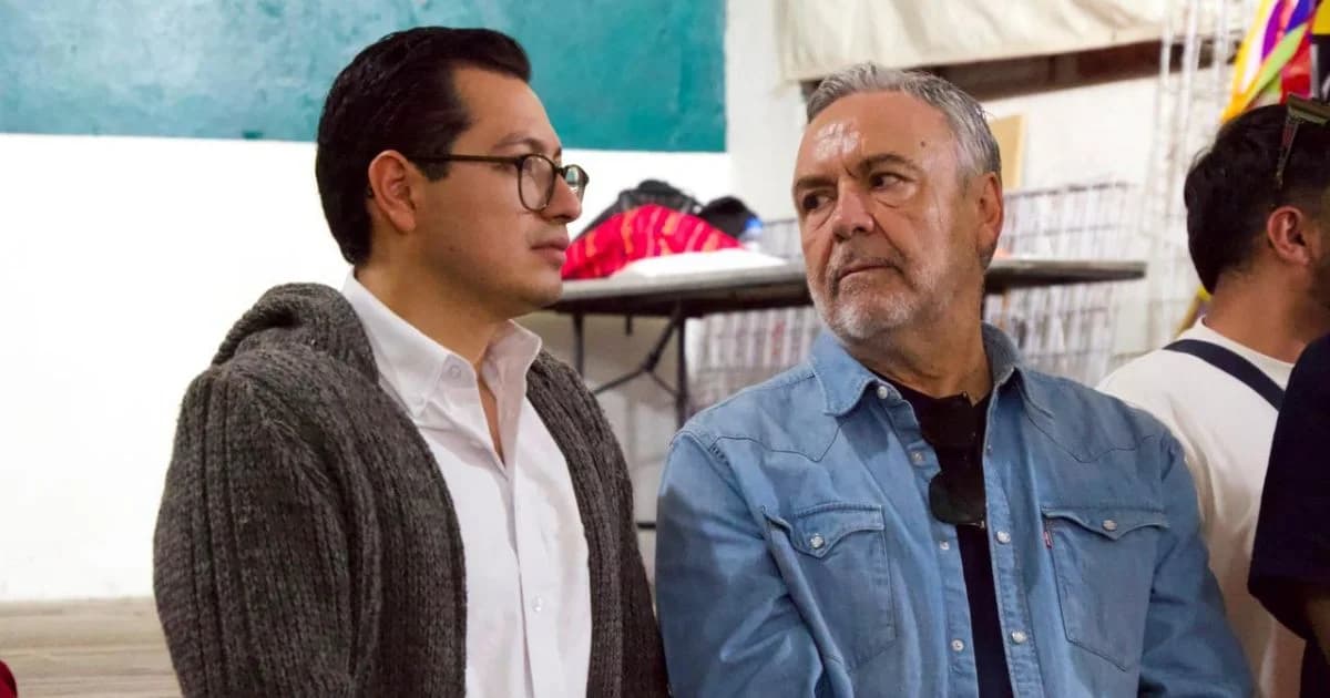 Dos hombres conversan durante un encuentro en un espacio interior