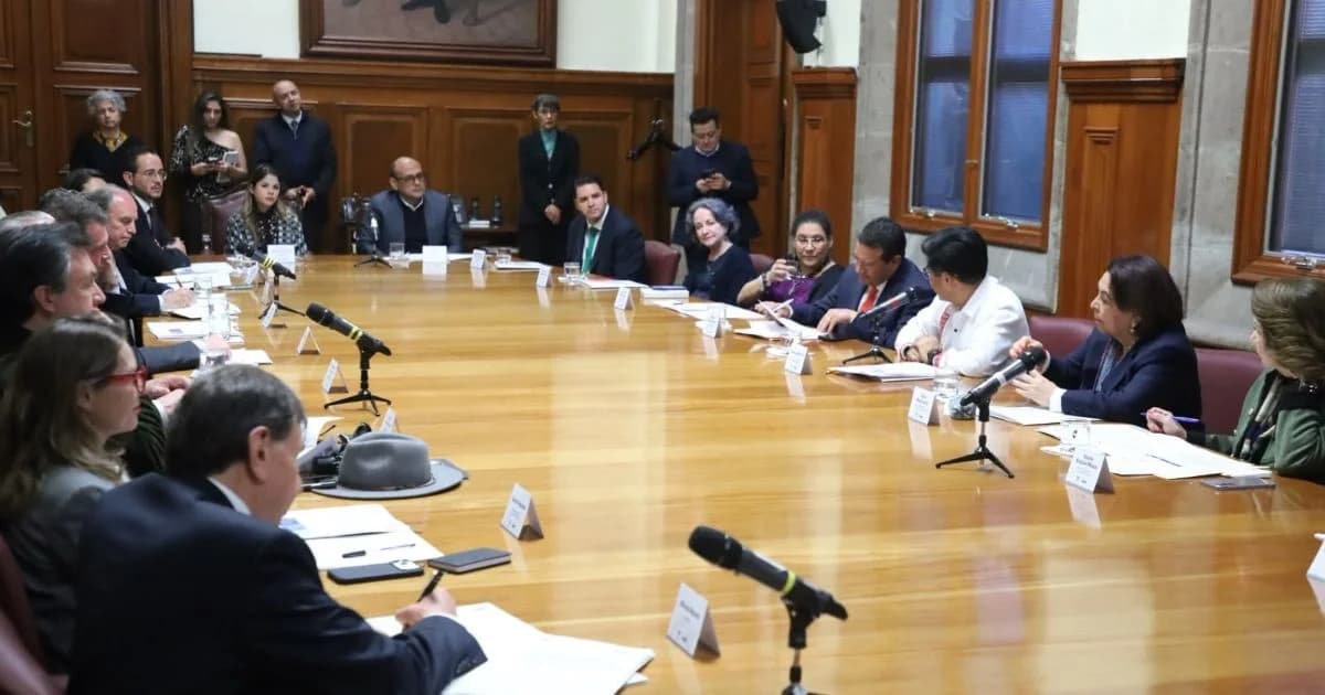 Mesa de reunión con representantes de instituciones judiciales y empresariales.