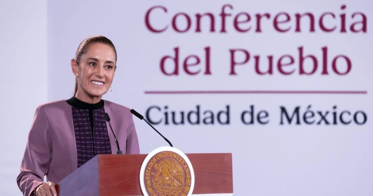 Mujer sonriente habla desde un podio durante la Conferencia del Pueblo en Ciudad de México