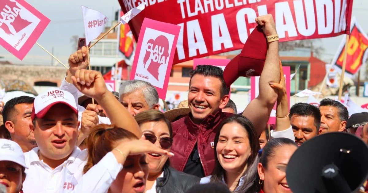 Concentración política con simpatizantes que levantan banderas y carteles de apoyo