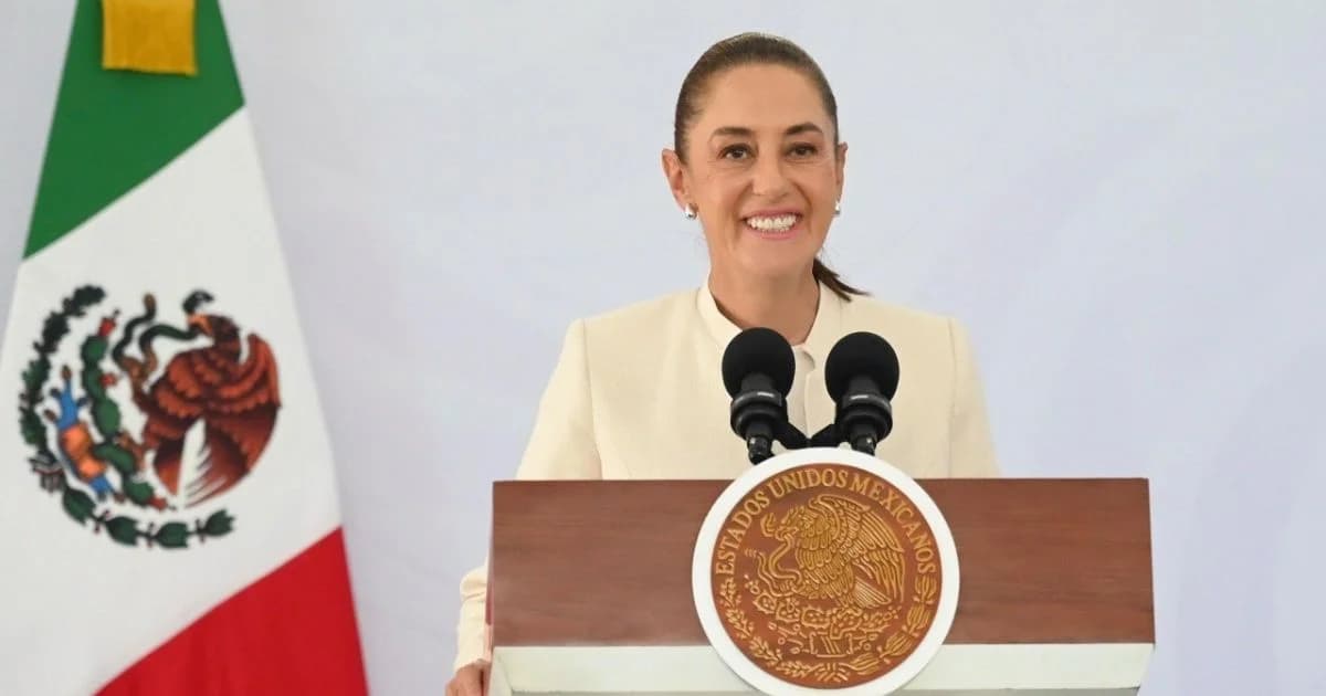 Una mujer habla desde un podio con el Escudo Nacional y la bandera de México a un costado.