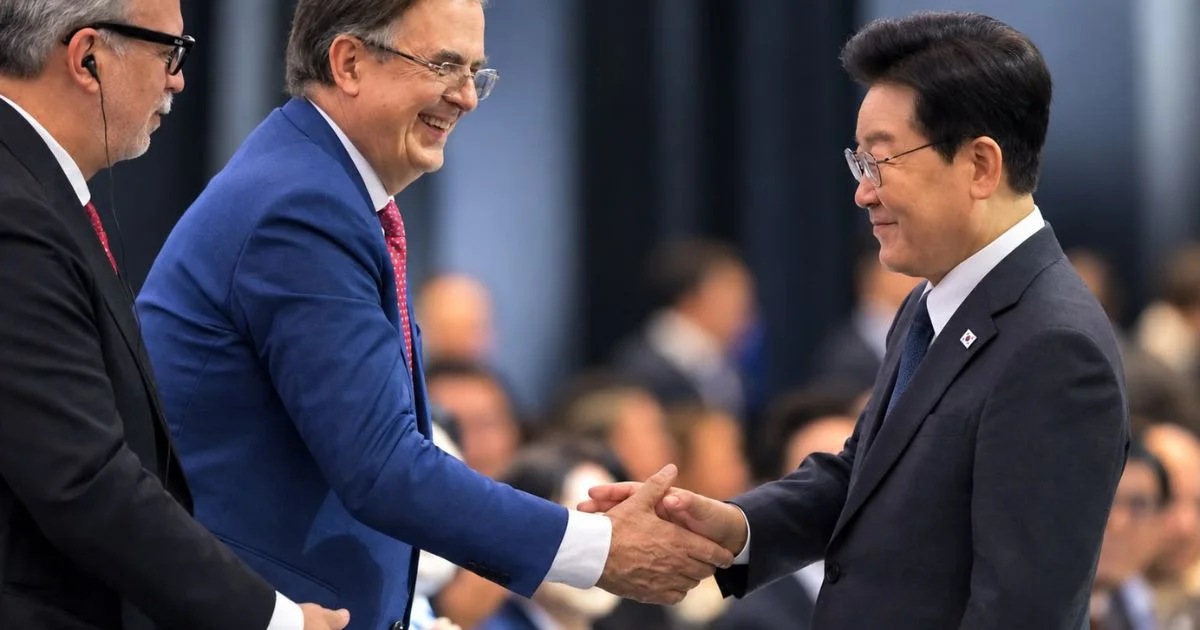 Dos hombres se estrechan la mano durante un encuentro empresarial, acompañados por otro participante.