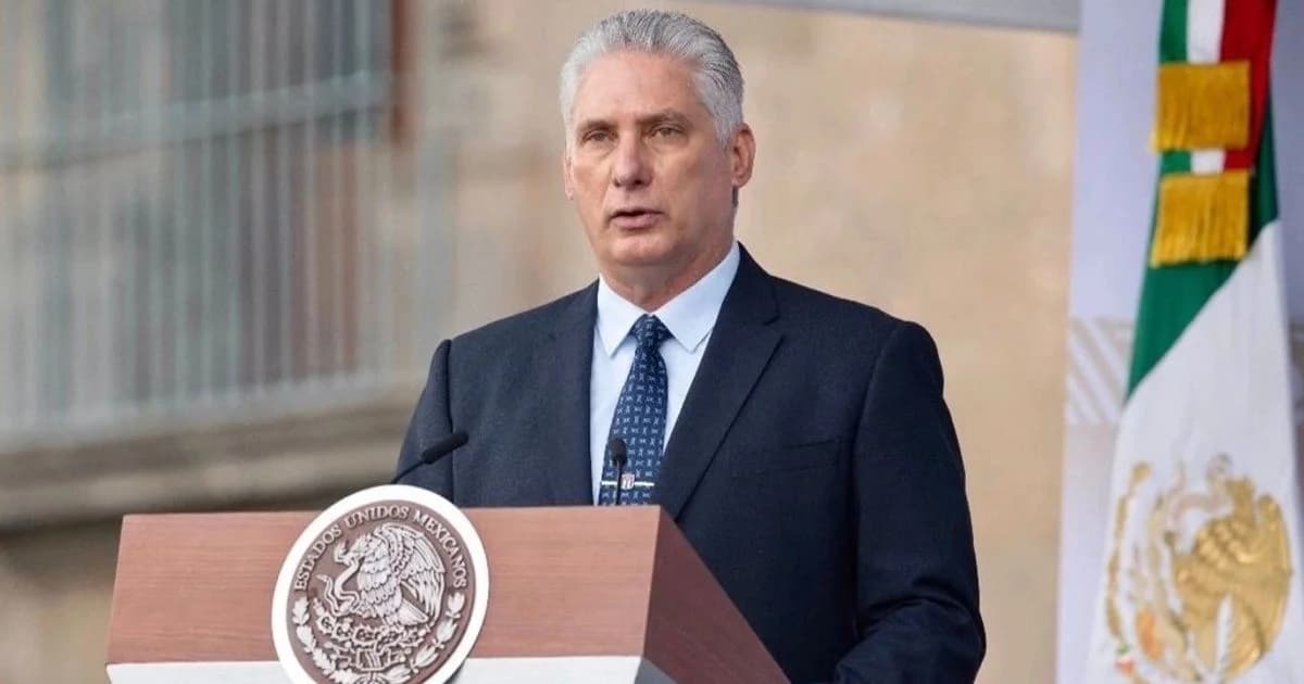 Hombre con traje habla desde un podio oficial con una bandera de México al fondo