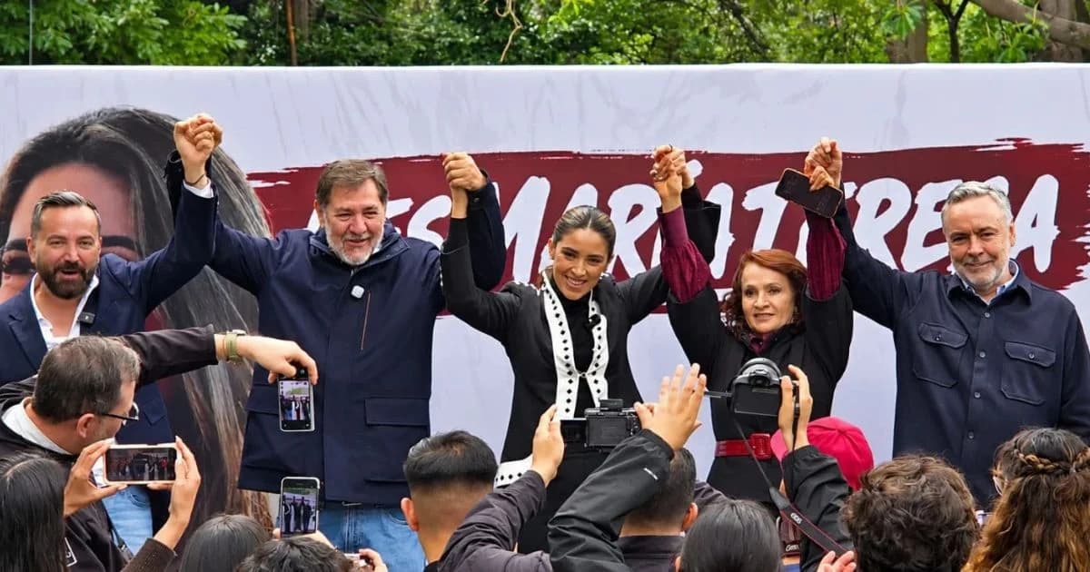 María Teresa Ealy levanta la mano junto a asistentes durante un acto público en Miguel Hidalgo.