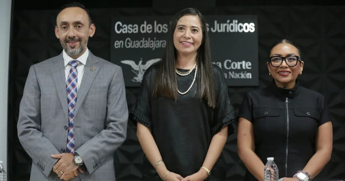 Tres participantes posan frente a un letrero de la Casa de los Saberes Jurídicos en Guadalajara durante un encuentro de justicia abierta