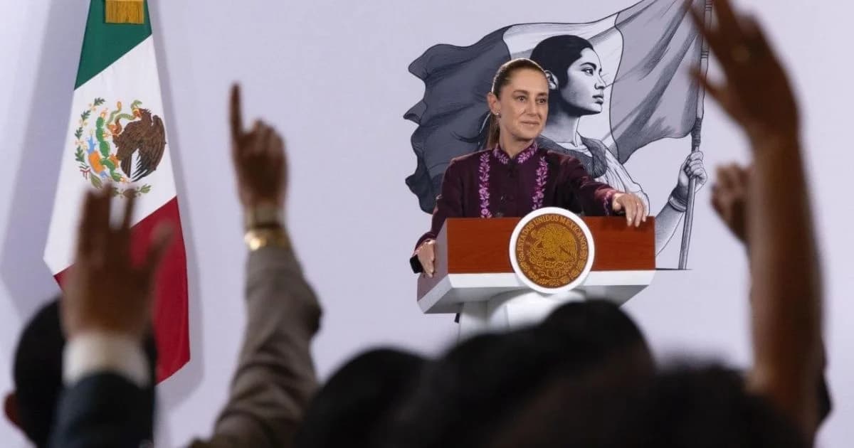 Una mujer habla desde el podio presidencial durante una conferencia de prensa, con una bandera de México a un costado y asistentes en primer plano